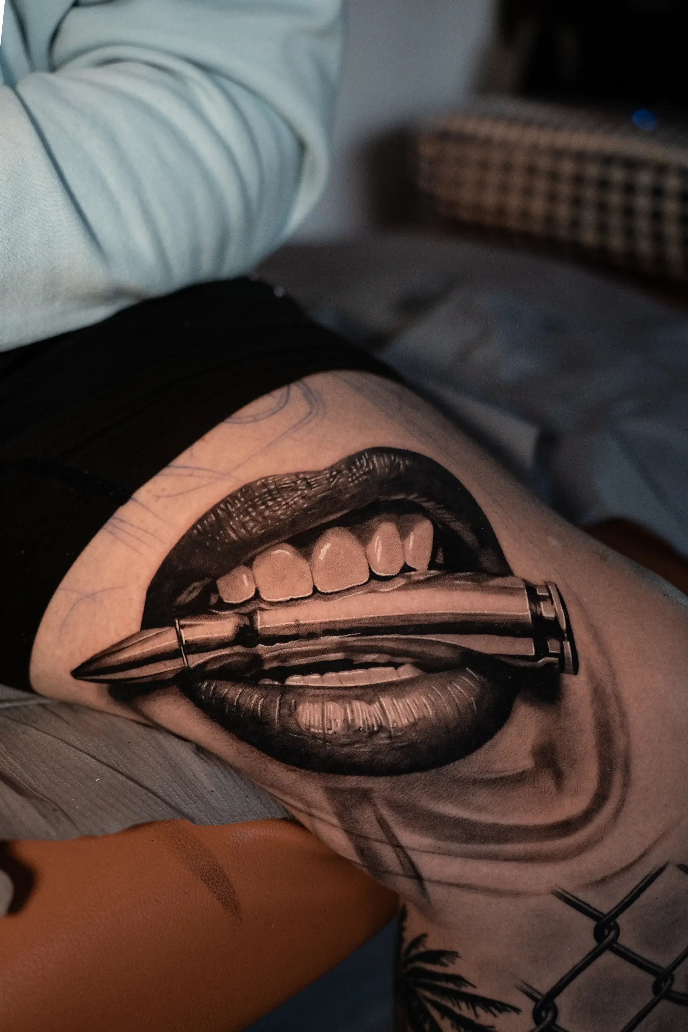 Realistic lady lips biting bullet tattoo by Devin