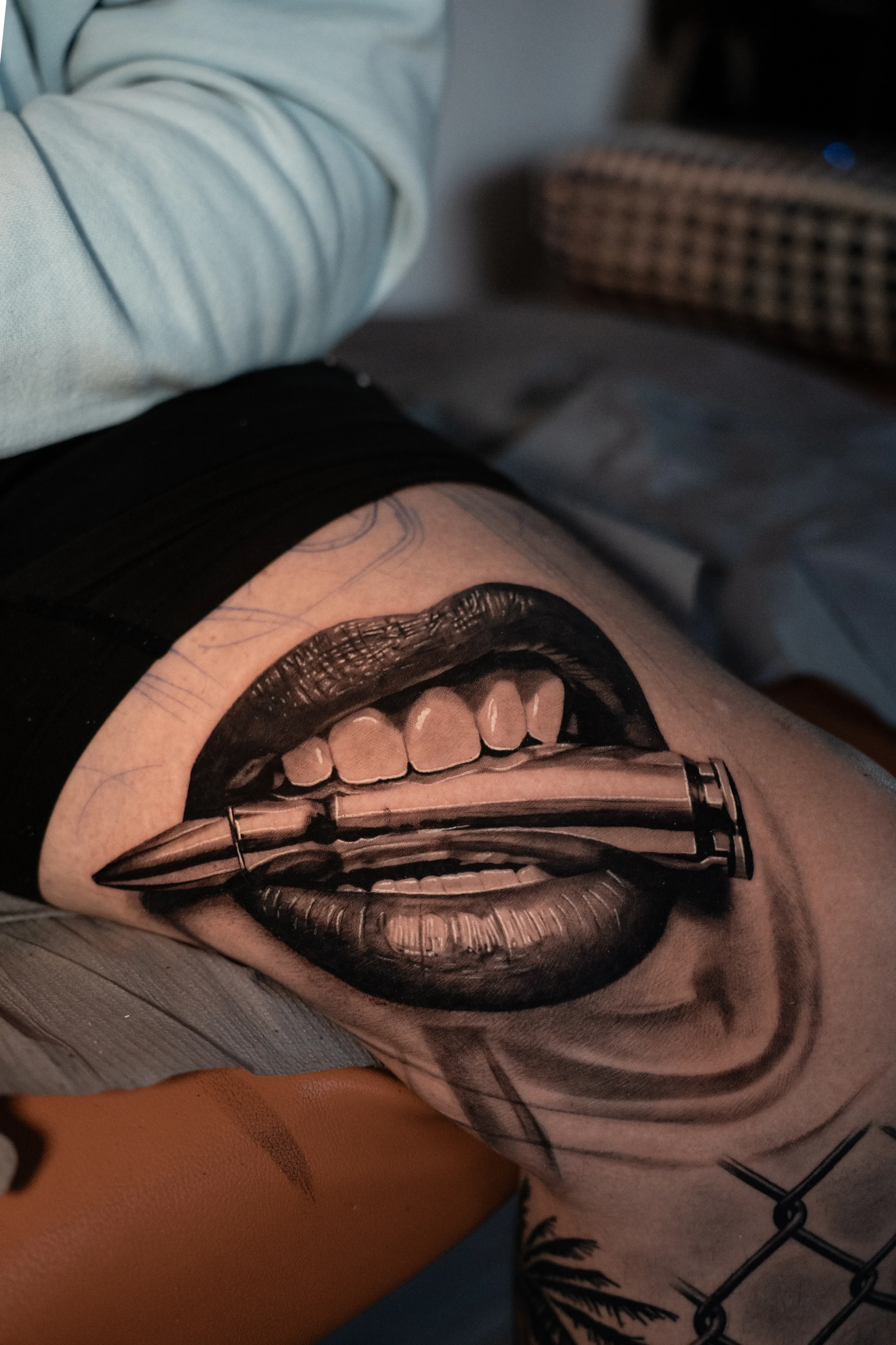 Lady lips biting bullet — dark realism tattoo by Devin Hesketh